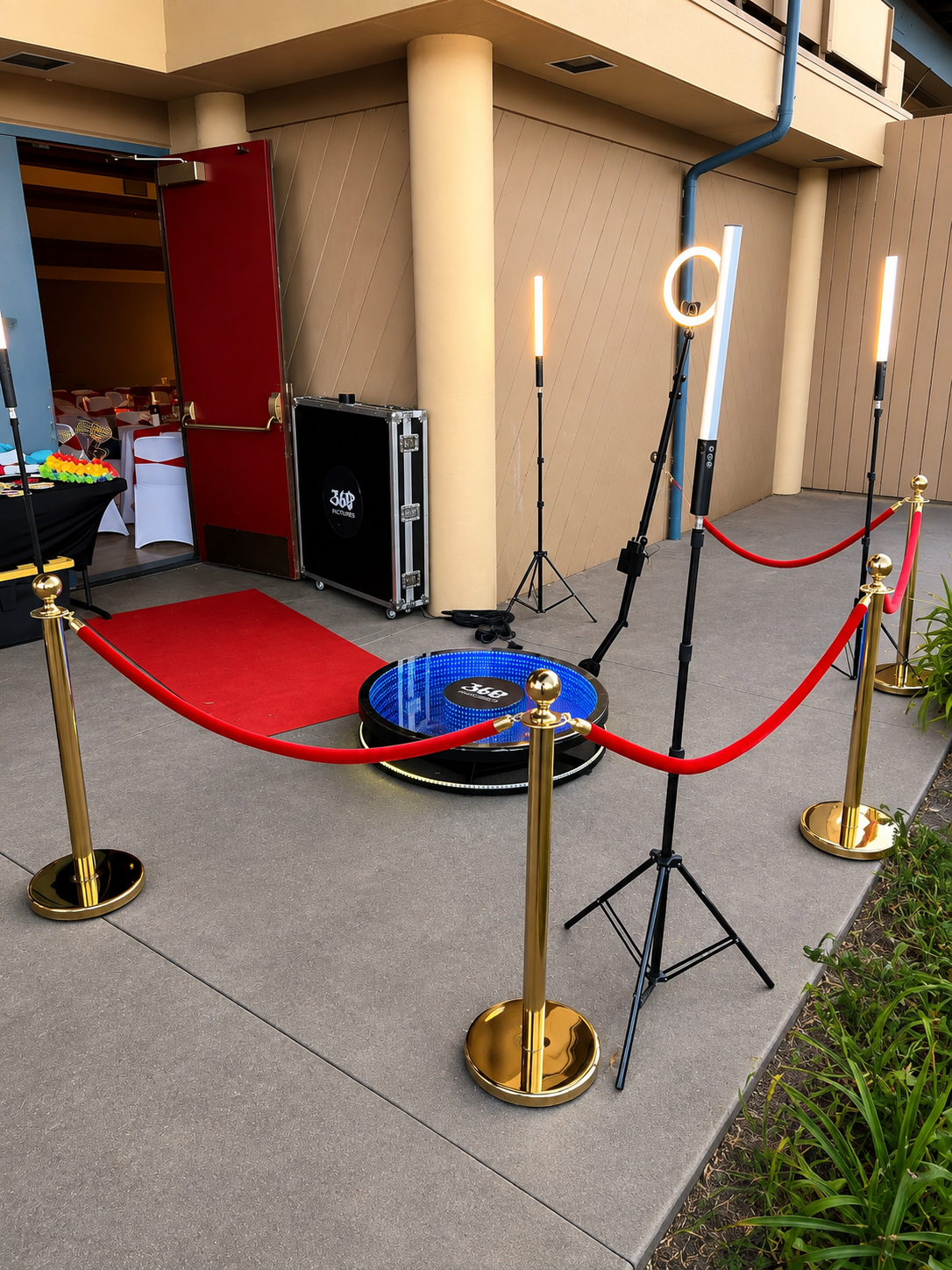 360 Photo Booth platform surrounded by lighting and red velvet ropes